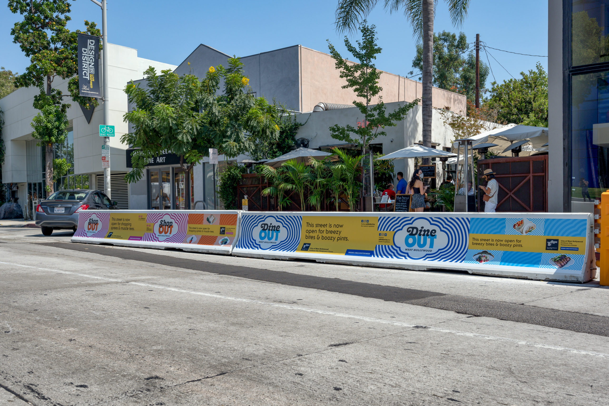 Branded WeHo OUT K-rail barriers seen on Santa Monica Blvd in West Hollywood. Branding and design by Kilter.